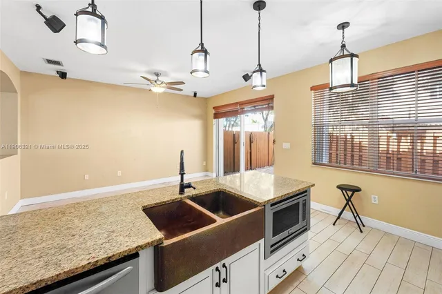 a kitchen with stainless steel appliances granite countertop a sink and a refrigerator