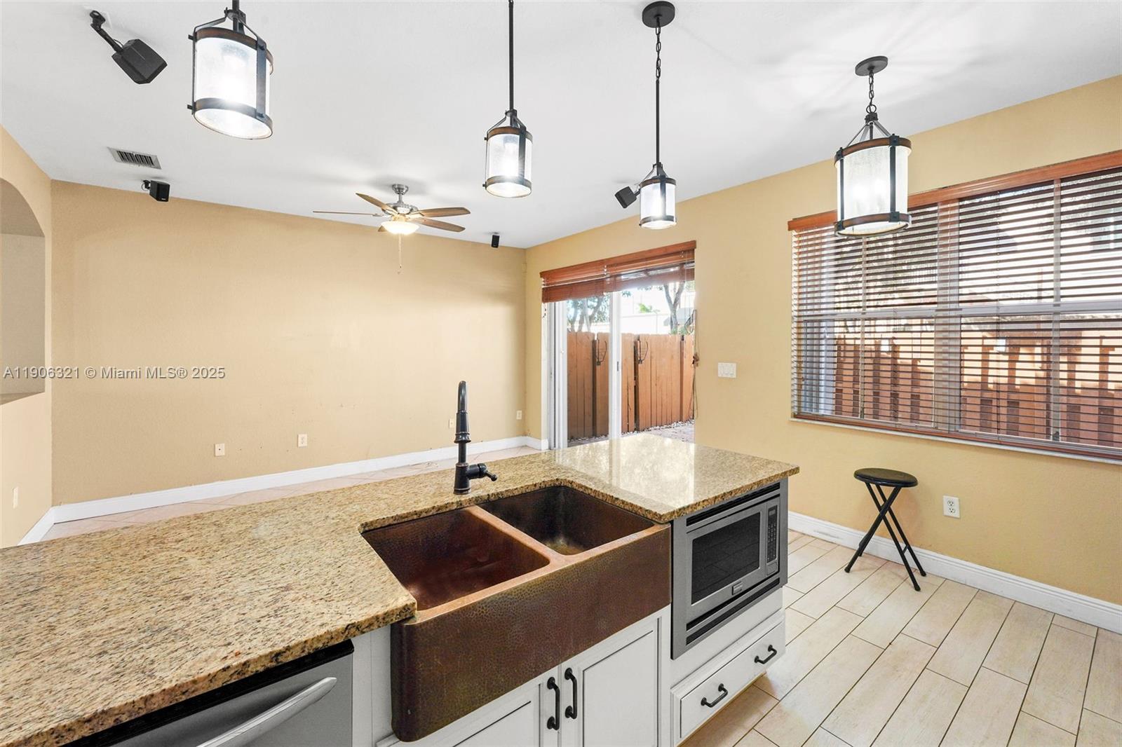 12513 Southwest 121st Way Miami, FL 33186 - Photo 19 of 37 a kitchen with stainless steel appliances granite countertop a sink and a refrigerator