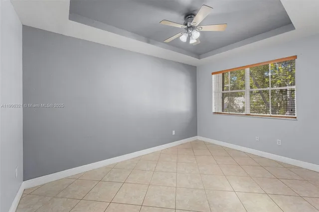 an empty room with windows and ceiling fan