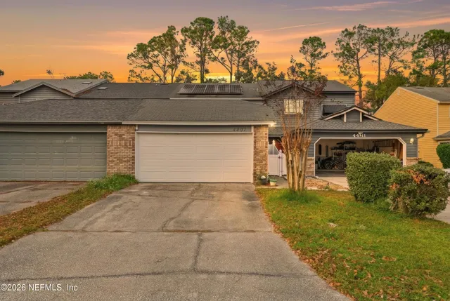 a view of a house with a yard and a garage