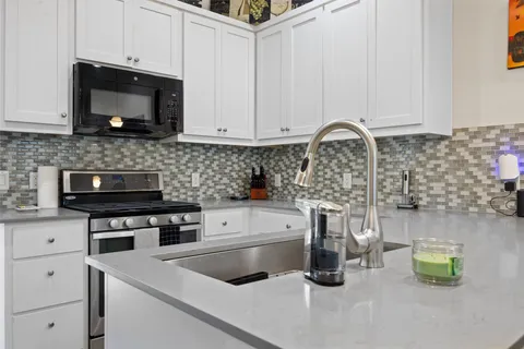a kitchen with a sink and white cabinets