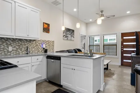 a kitchen with white cabinets and sink