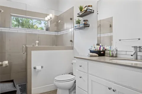 a bathroom with a sink and mirror with toilet
