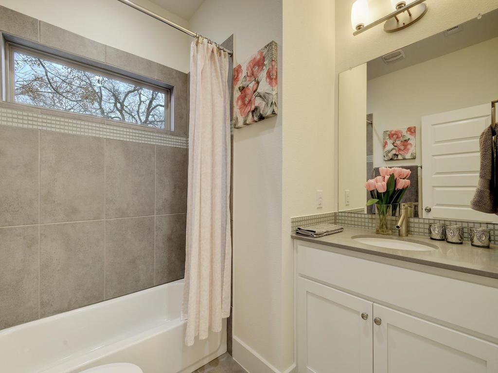 720 Pedernales Street, Unit B Austin, TX 78702 - Photo 10 of 15 a bathroom with a granite countertop sink mirror vanity and bathtub