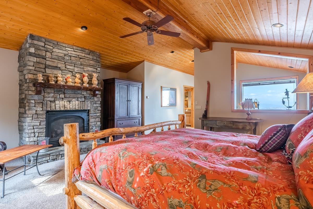 629 John Muir Road Mammoth Lakes, CA 93546 - Photo 27 of 49 a bedroom with a bed and a fireplace