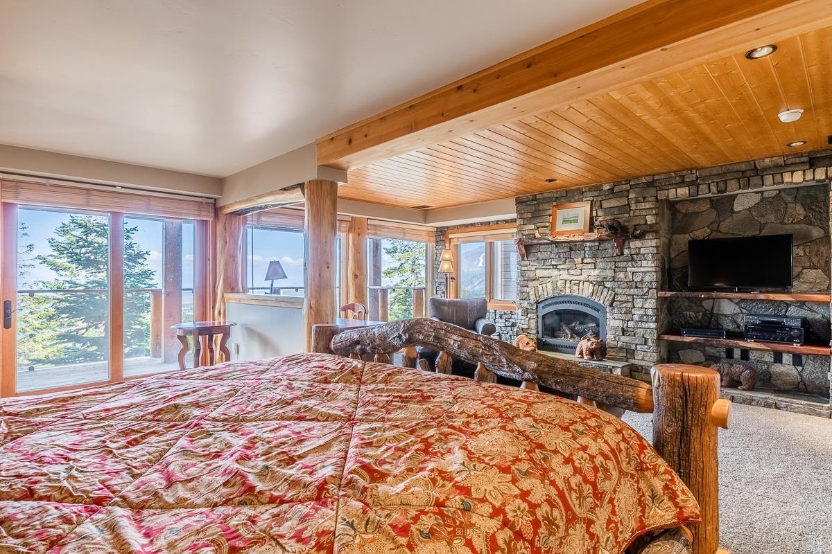 629 John Muir Road Mammoth Lakes, CA 93546 - Photo 40 of 49 a large bedroom with furniture fireplace and flat screen tv