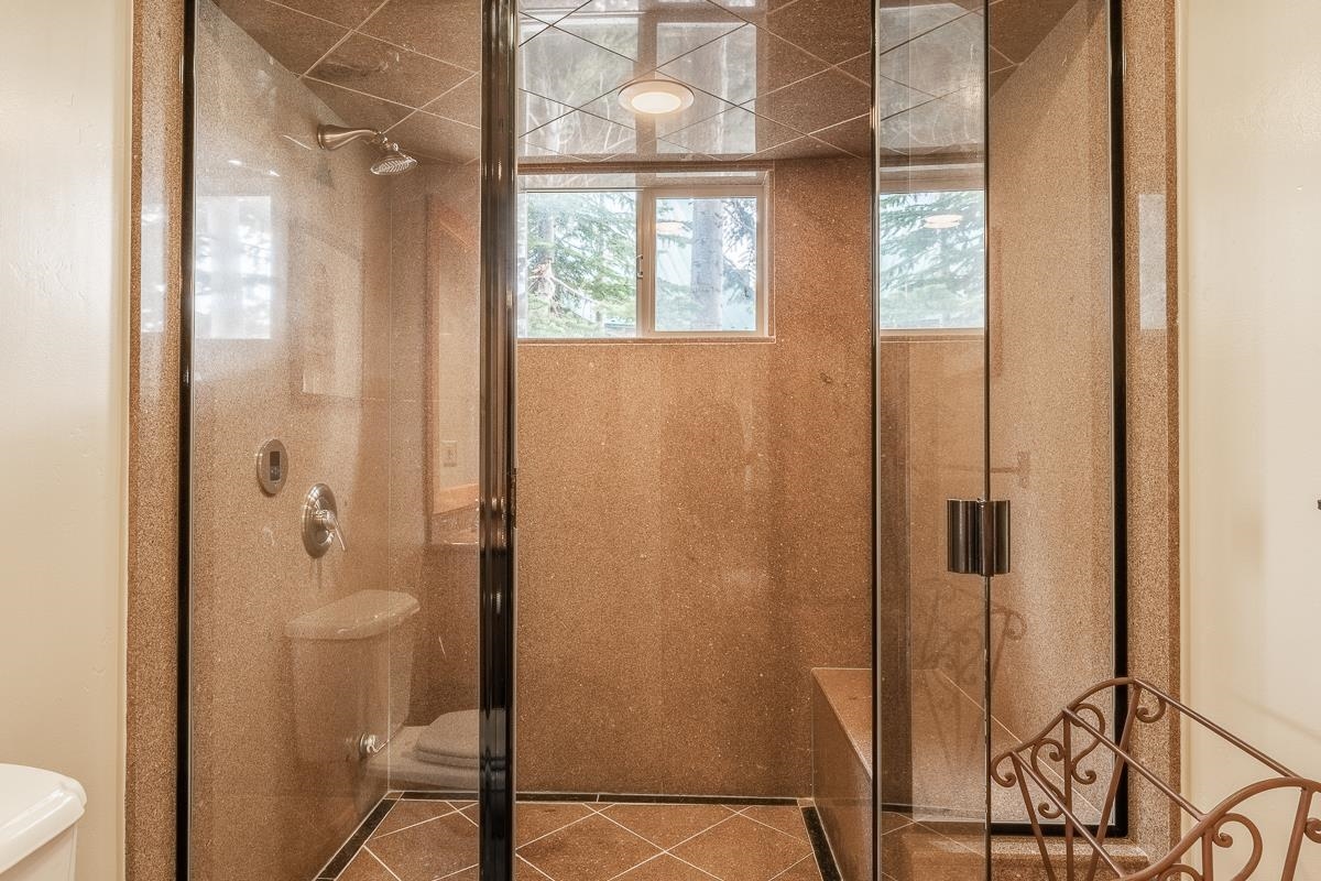 629 John Muir Road Mammoth Lakes, CA 93546 - Photo 46 of 49 a bathroom with a granite countertop shower and a toilet
