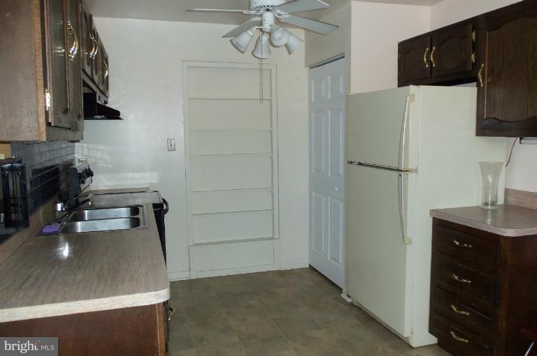 977 Grace Road Huntingtown, MD 20639 - Photo 12 of 14 a kitchen with a refrigerator and a stove top oven