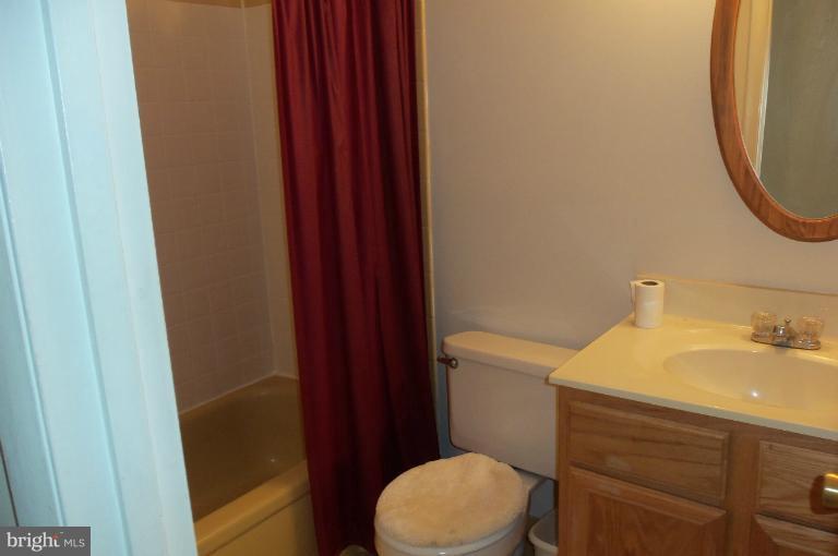 977 Grace Road Huntingtown, MD 20639 - Photo 3 of 14 a bathroom with a sink a toilet and a mirror