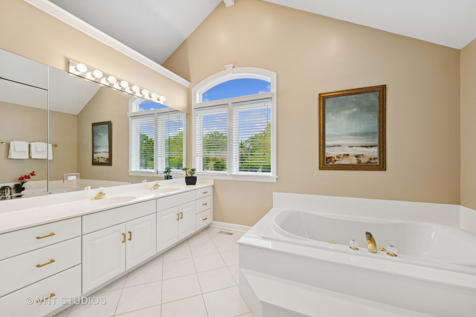 11 Longmeadow Road Winnetka, IL 60093 - Photo 19 of 31 a bathroom with a sinks a large mirror and a bathtub next to a window