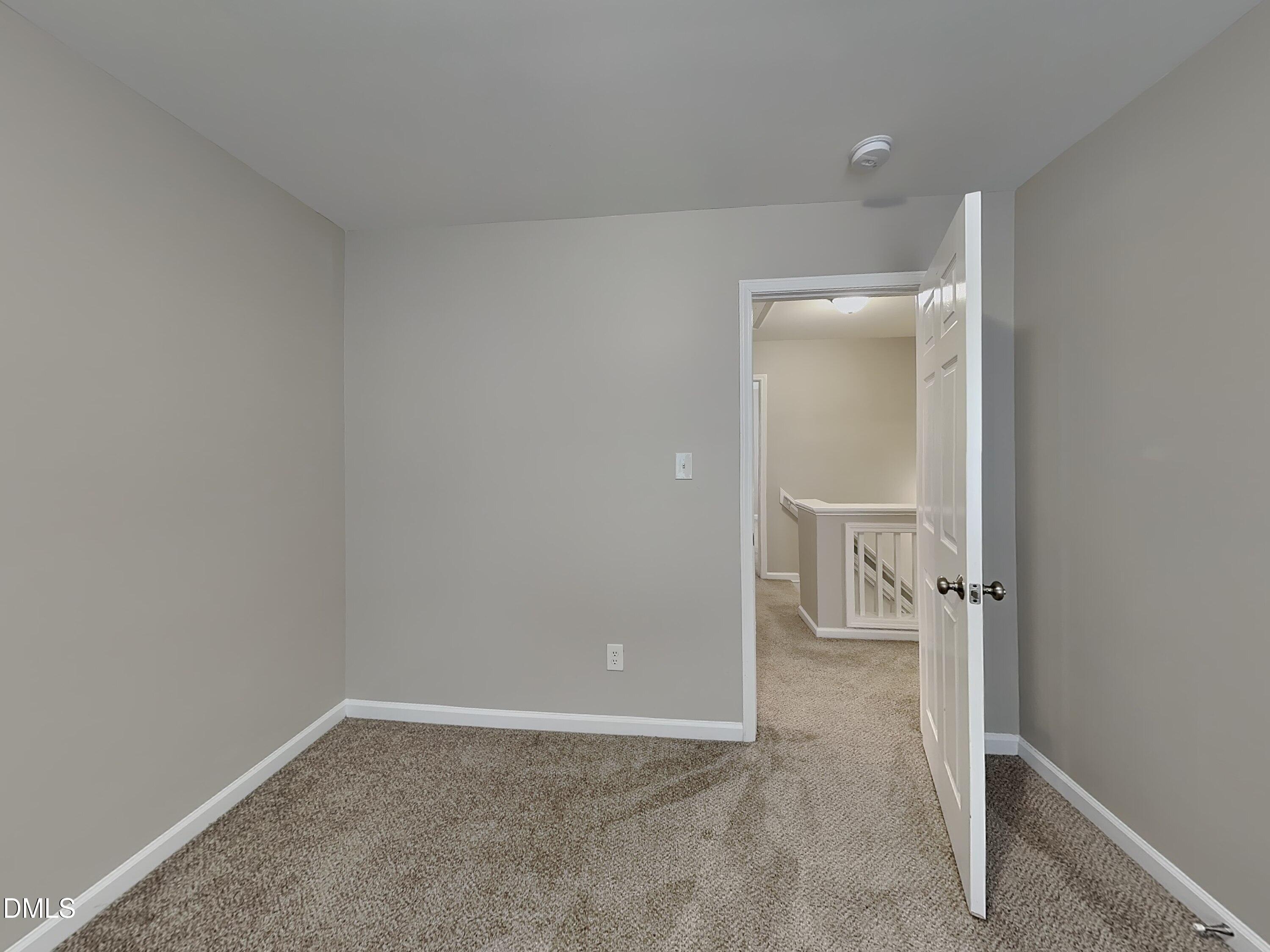 4053 Laurel Glen Drive Raleigh, NC 27610 - Photo 14 of 20 an empty room with wooden floor and a bathroom