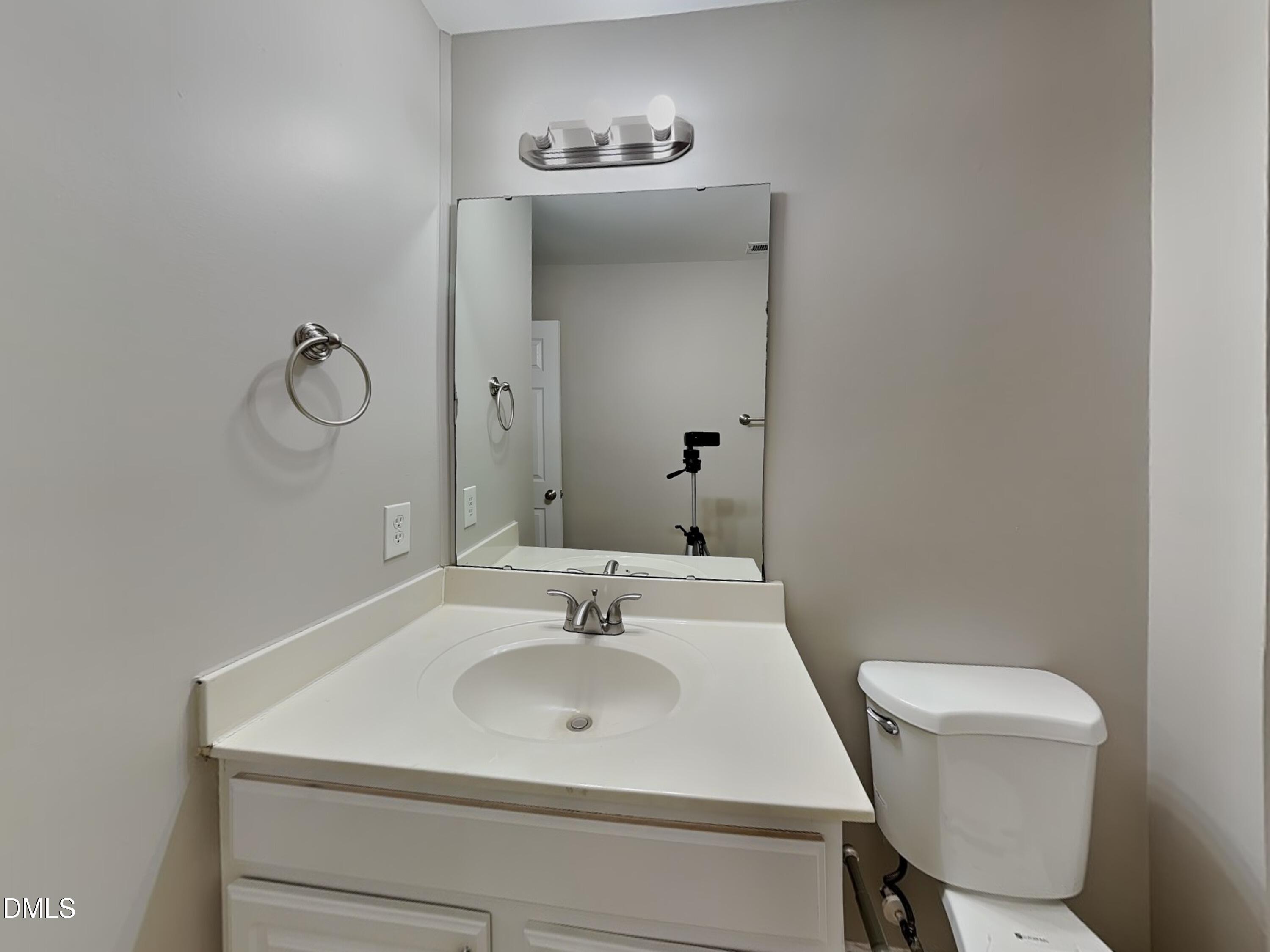 4053 Laurel Glen Drive Raleigh, NC 27610 - Photo 16 of 20 a bathroom with a sink a toilet and a mirror