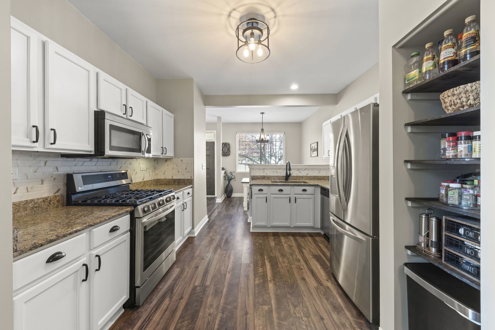 2263 Reflections Drive Aurora, IL 60502 - Photo 11 of 31 a kitchen with stainless steel appliances a refrigerator a stove a sink cabinets and a wooden floor