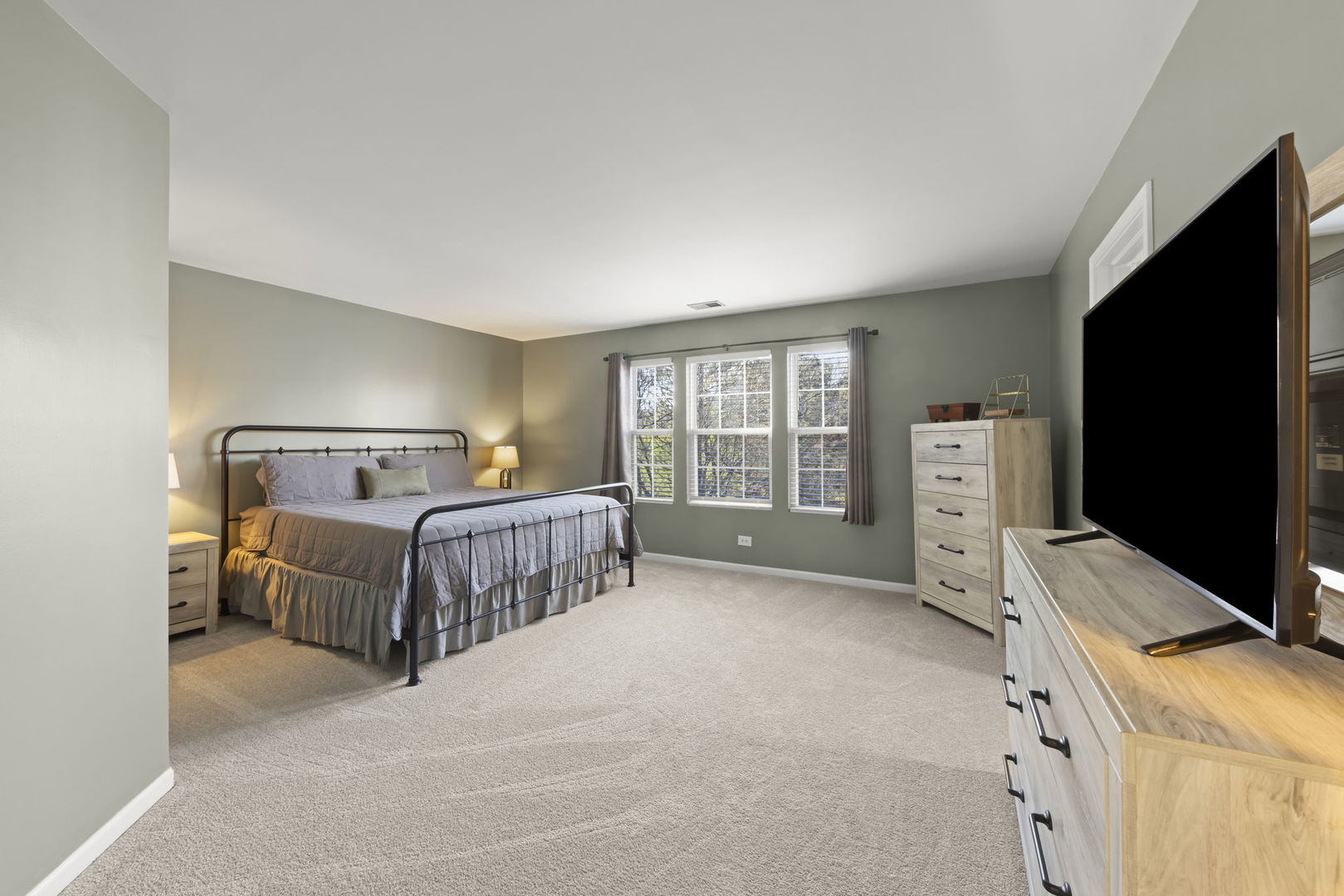 2263 Reflections Drive Aurora, IL 60502 - Photo 16 of 31 a spacious bedroom with a bed and a flat tv screen on dresser