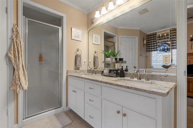 a bathroom with a granite countertop sink two mirror and a shower