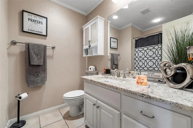 a bathroom with a granite countertop sink a toilet and mirror