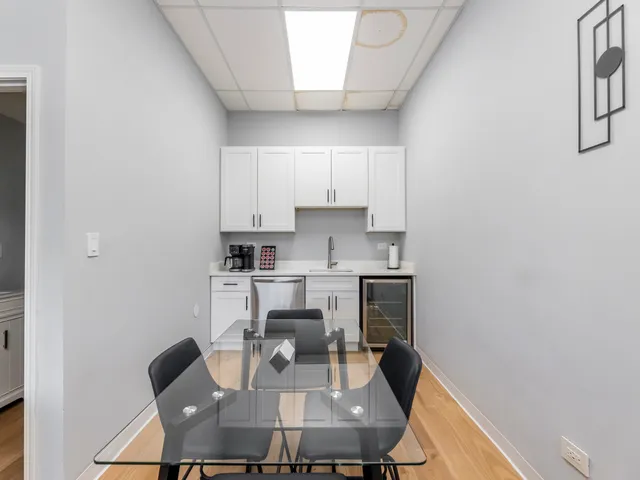 a kitchen with a dining table chairs and a refrigerator