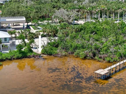 an aerial view of a house with a yard and lake view