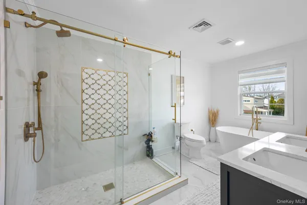 a bathroom with a granite countertop shower sink vanity and mirror