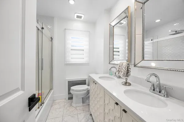 a bathroom with a double vanity sink a toilet and a mirror