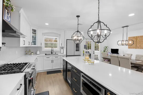 a kitchen with stainless steel appliances a table chairs and cabinets