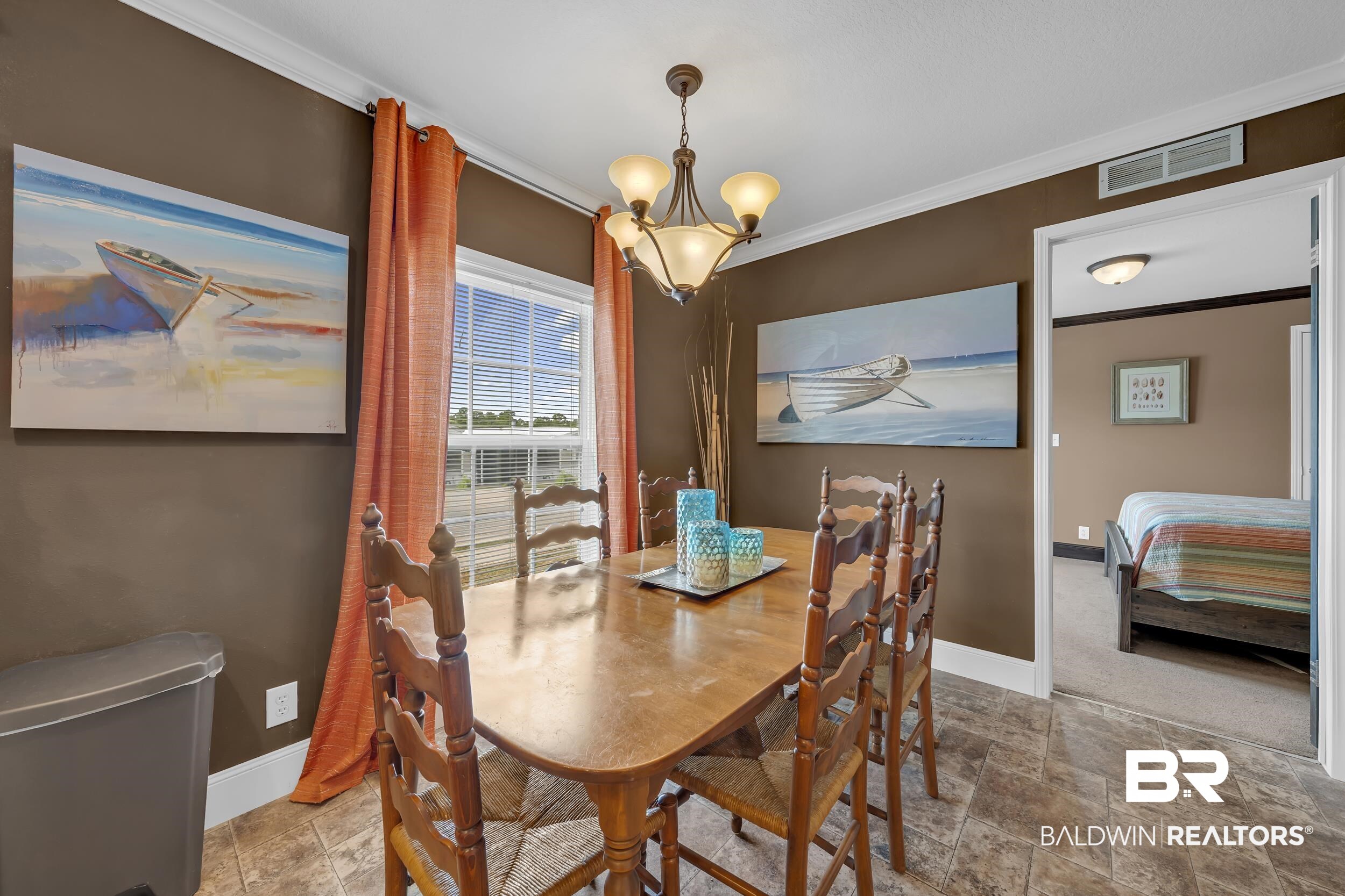 16707 Fort Morgan Road, Unit 8 Gulf Shores, AL 36542 - Photo 25 of 27 Dining room with crown molding, stone finish floors, and a chandelier
