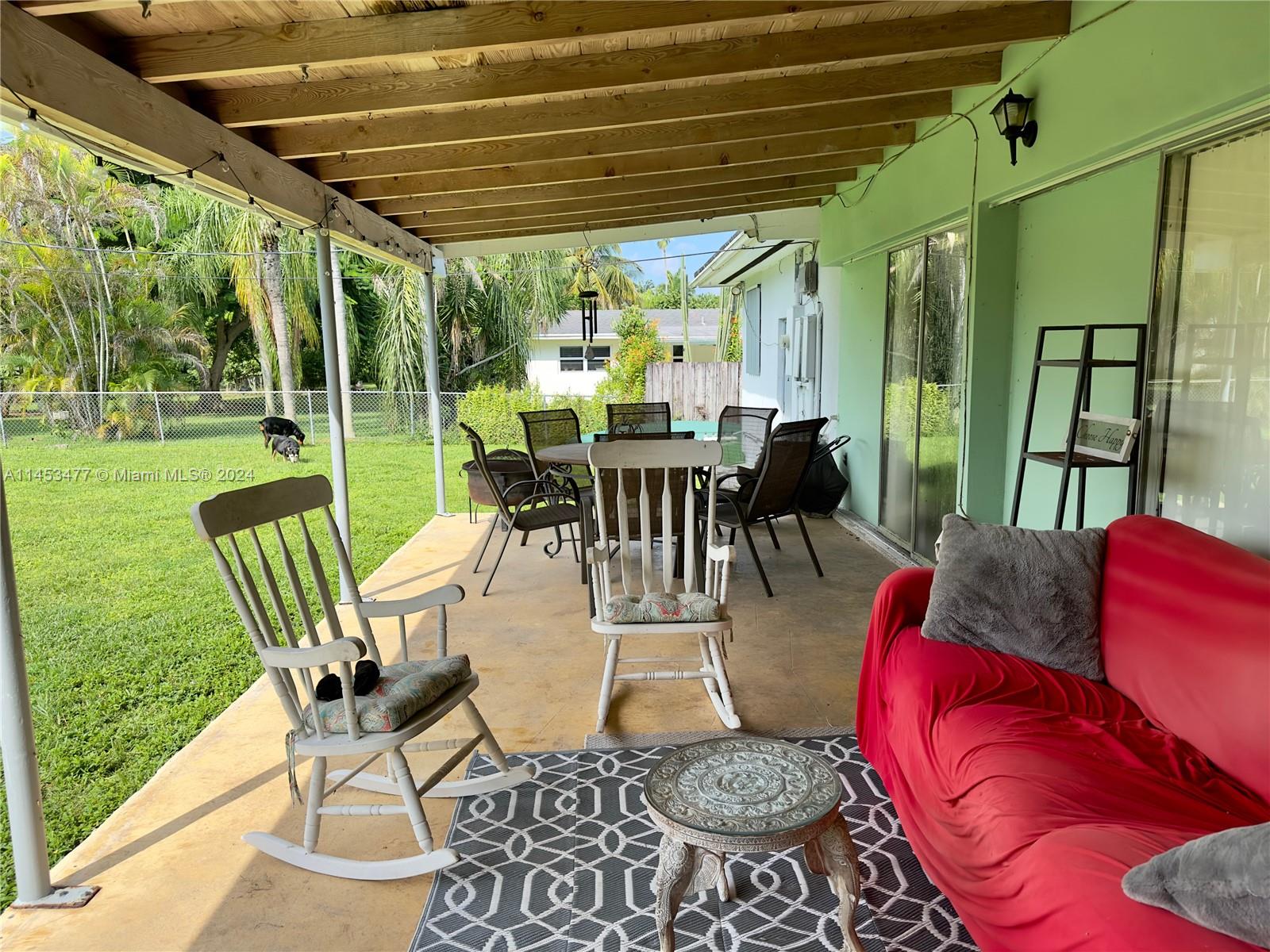 9320 Southwest 125th Terrace Miami, FL 33176 - Photo 18 of 31 a view of a patio with table and chairs potted plants and large tree