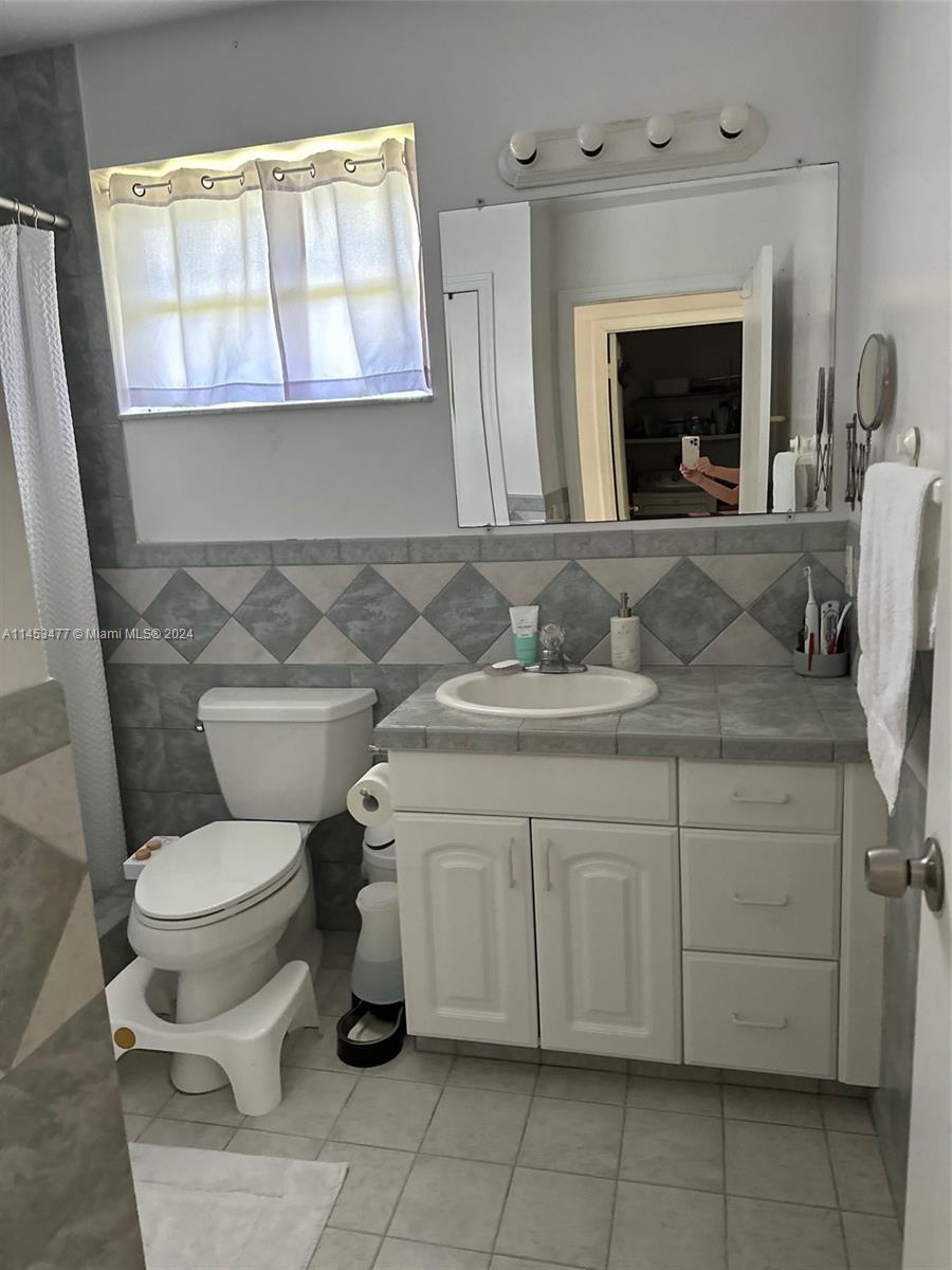 9320 Southwest 125th Terrace Miami, FL 33176 - Photo 29 of 31 a bathroom with a toilet sink and mirror