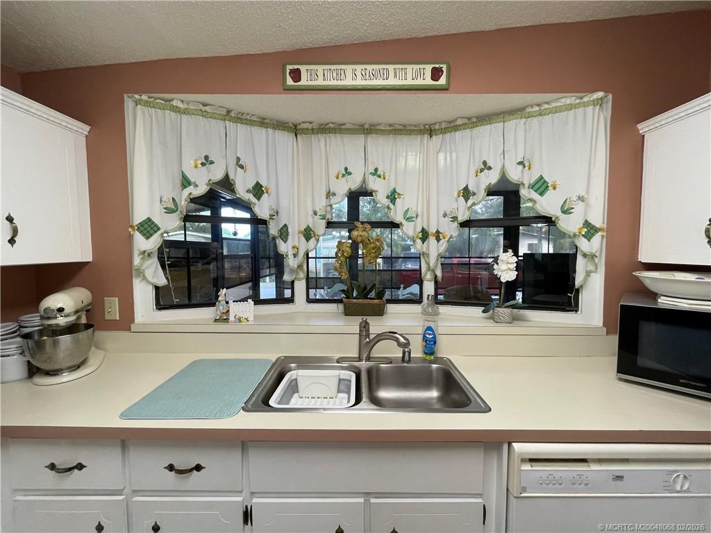 16236 Southwest Three Wood Way Indiantown, FL 34956 - Photo 11 of 26 a kitchen with a sink and a stove top oven