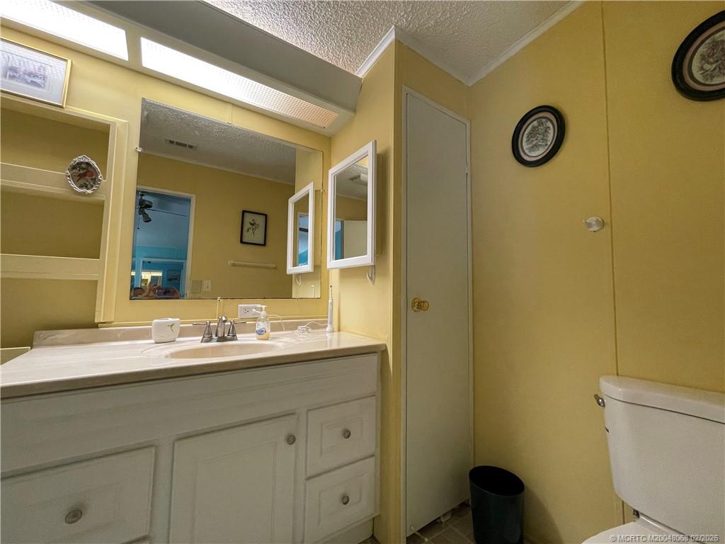 16236 Southwest Three Wood Way Indiantown, FL 34956 - Photo 15 of 26 a bathroom with a sink mirror vanity and toilet