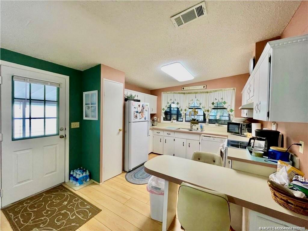 16236 Southwest Three Wood Way Indiantown, FL 34956 - Photo 2 of 26 a room with a table chairs and a refrigerator