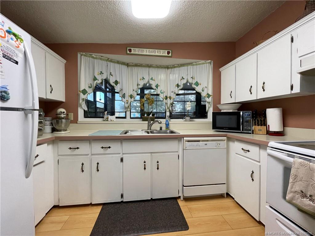 16236 Southwest Three Wood Way Indiantown, FL 34956 - Photo 3 of 26 a kitchen with granite countertop a sink stainless steel appliances and cabinets