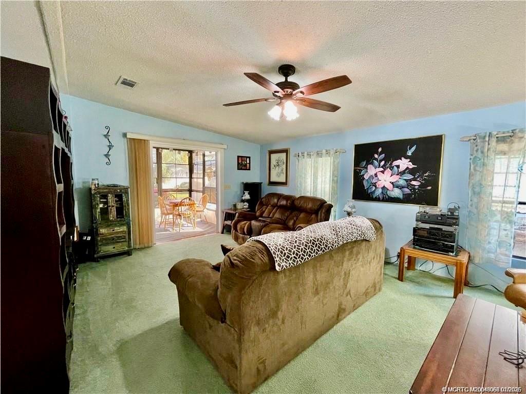 16236 Southwest Three Wood Way Indiantown, FL 34956 - Photo 5 of 26 a living room with furniture a large window and a flat screen tv