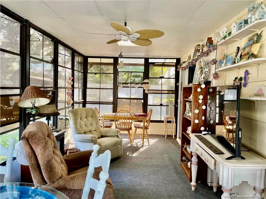 16236 Southwest Three Wood Way Indiantown, FL 34956 - Photo 7 of 26 a living room with furniture a chandelier and a floor to ceiling window