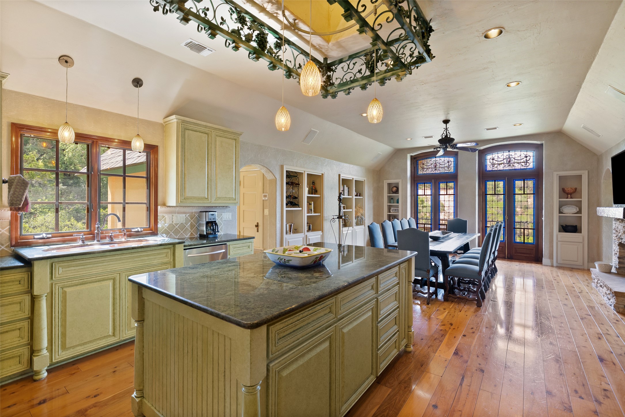 1354 The High Road Austin, TX 78746 - Photo 16 of 40 An inviting open-concept kitchen boasts a large island and ample space, flowing seamlessly into the dining area with rich hardwood floors.