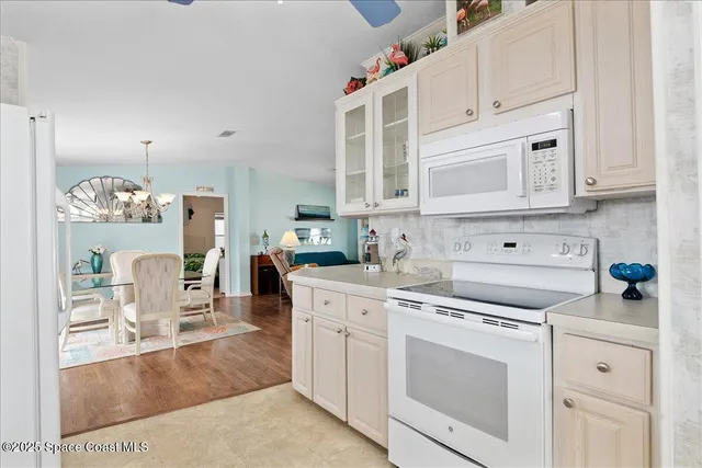 a kitchen with cabinets appliances and a wooden floor