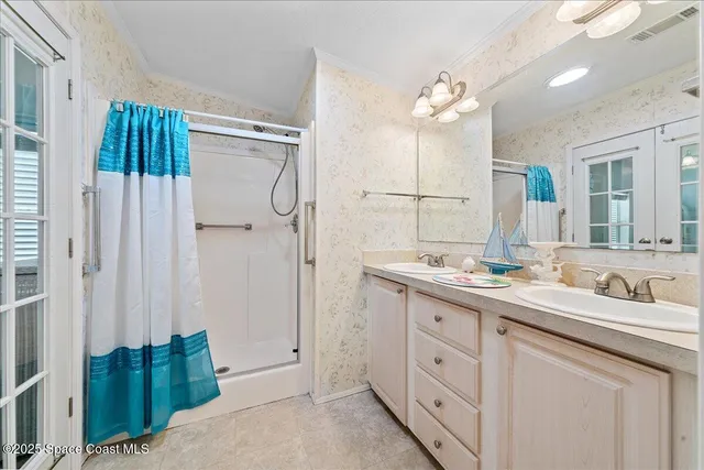 a spacious bathroom with a double vanity sink a large mirror and shower