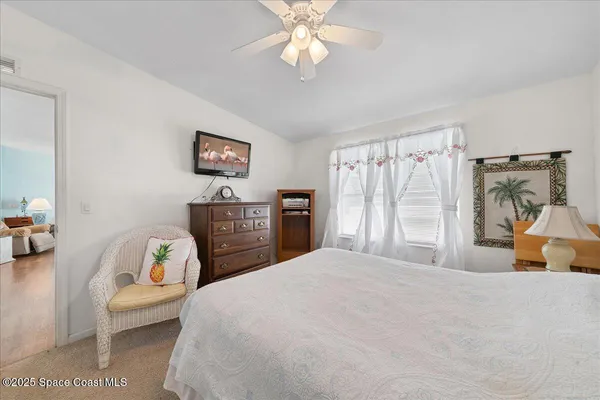 a bedroom with a bed a couch and a chandelier