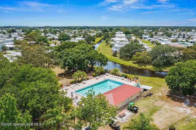 an aerial view of residential houses with outdoor space and trees
