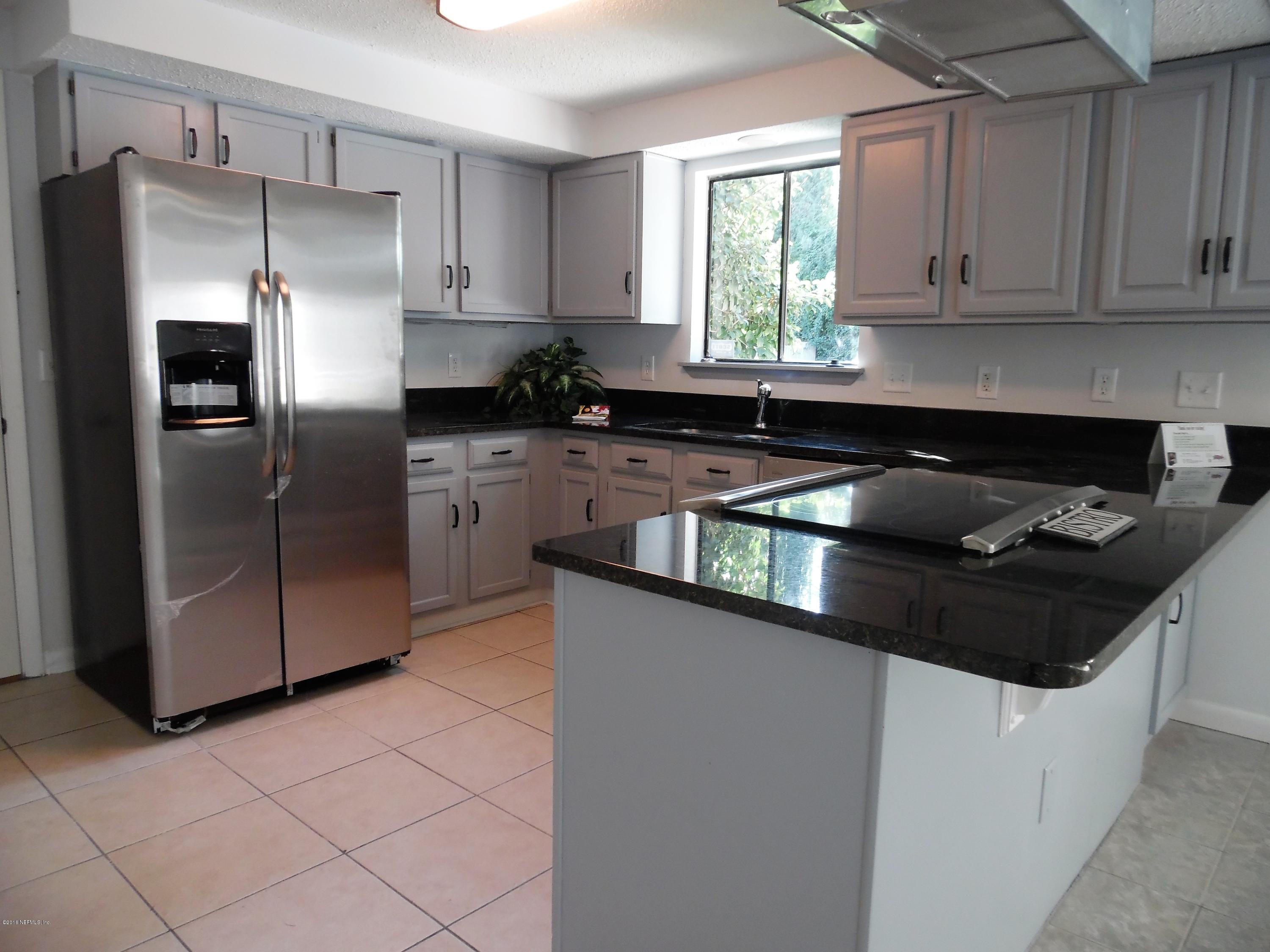 10244 Pine Breeze Road South Jacksonville, FL 32257 - Photo 23 of 27 a kitchen with granite countertop a refrigerator sink and cabinets