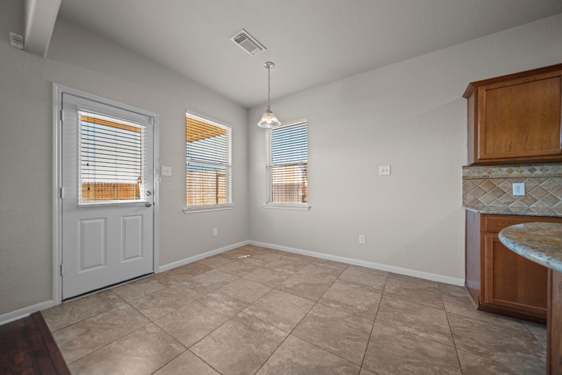 6047 Northcrest Village Way Spring, TX 77388 - Photo 12 of 30 a view of an empty room with a window and a kitchen