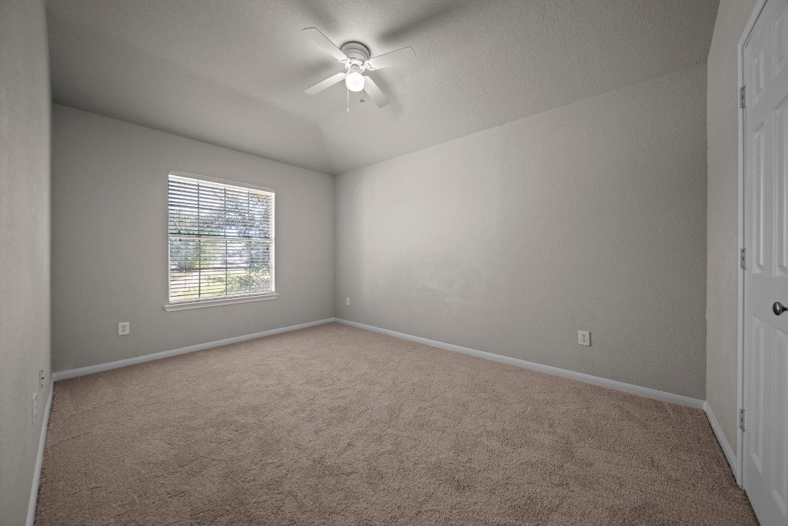 6047 Northcrest Village Way Spring, TX 77388 - Photo 19 of 30 en empty room with windows and chandelier fan