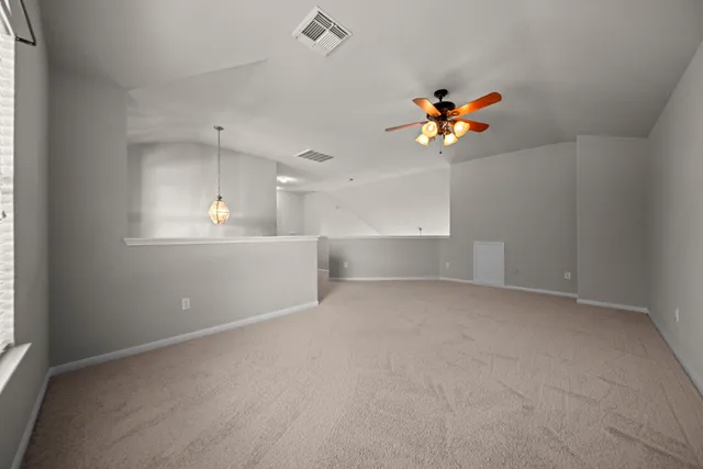 an empty room with windows and fan