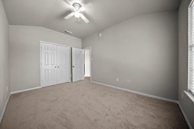 en empty room with windows and fan