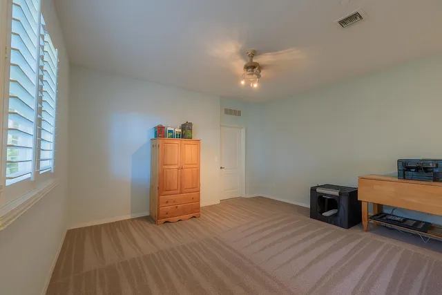 a view of a room with wooden floor and ceiling fan