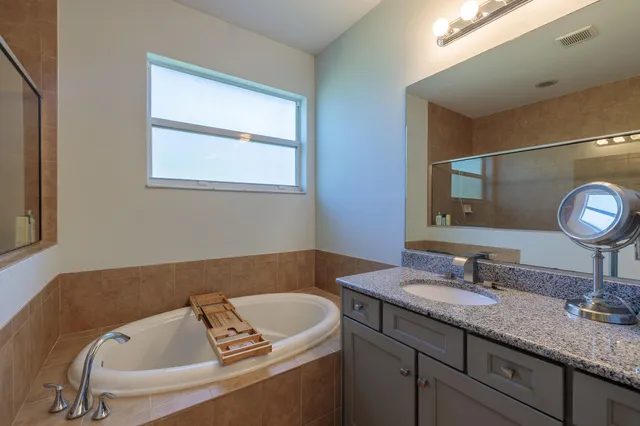 a bathroom with a granite countertop sink a mirror and