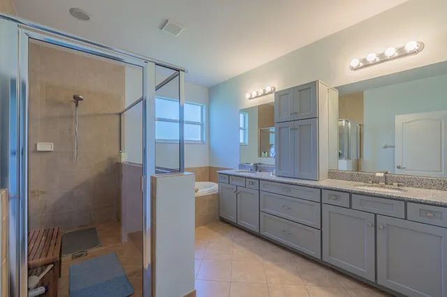 a bathroom with a double vanity sink mirror and shower