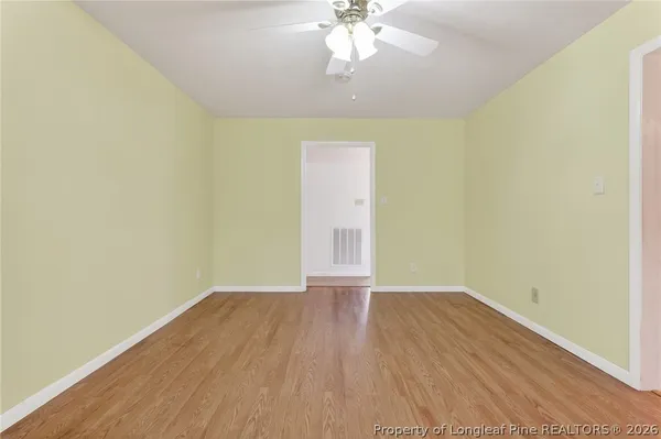 a view of an empty room with wooden floor