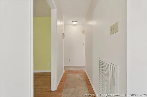 a view of a hallway with wooden floor