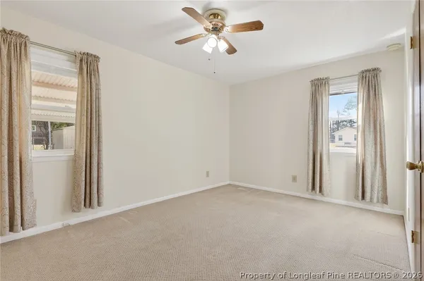 a view of an empty room and a ceiling fan